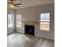 Inviting living room features a cozy fireplace, modern ceiling fan, and natural light at 135 Jones Creek Ln, Lillington, NC 27546