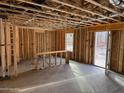 A view of an unfinished room featuring exposed stud walls, a concrete floor, and a window providing natural light at 36 Horse Trot Ln, Sanford, NC 27330