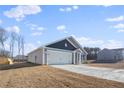 Gray house with a two-car garage and partial view of another house at 216 Barnsley Rd, Angier, NC 27501