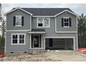 Two-story home with gray siding and dark shutters, large windows providing natural light, and attached garage at 352 Rocking Horse Ln, Sanford, NC 27332