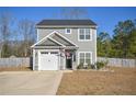 Charming two-story home with gray siding, a black door, an American flag, and a well-maintained front yard at 206 Westpark Ln, Sanford, NC 27332