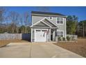 Charming two-story home with gray siding, a black door, an American flag, and a well-maintained front yard at 206 Westpark Ln, Sanford, NC 27332