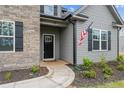 Inviting entryway with a black front door, stone accents, and tasteful landscaping at 37 Pomegranate Ct, Cameron, NC 28326