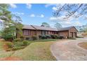 Landscaped home with brick and garage, showcasing the front yard and driveway at 48 Indian Trl, Sanford, NC 27332