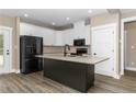 Modern kitchen featuring white cabinets, a black island, and stainless steel appliances at 541 Delma Grimes Rd, Coats, NC 27521