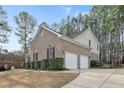 Brick home showcasing a two-car garage, manicured hedges, and a concrete driveway at 61 Fountain Park Cir, Spring Lake, NC 28390