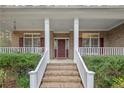 Inviting front porch with brick steps, white railings, and a decorative front door at 61 Fountain Park Cir, Spring Lake, NC 28390