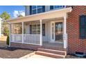 Covered front porch with white railings and brick flooring at 145 Rolling Stone Ct, Sanford, NC 27332