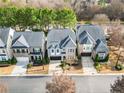 Aerial view of a row of houses with gray roofs and tree-lined street at 4008 Windflower Ln, Raleigh, NC 27612