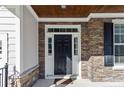Front entrance with stone accents and a dark-stained wooden door at 597 Micahs N Way, Spring Lake, NC 28390