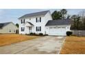 Charming two-story home with a well-kept lawn and a spacious driveway leading to an attached two-car garage at 86 Carolina Oaks Cir, Linden, NC 28356