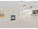 Bright living room with a fireplace, ceiling fan, and view of the kitchen area at 90 Orchard Falls Dr, Spring Lake, NC 28390