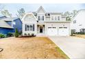 Charming two-story home showcasing a manicured lawn and a two-car garage at 87 Education Dr, Spring Lake, NC 28390