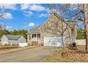 Side view of the home with a two-car garage and well-maintained lawn at 10 Tory Ct, Lillington, NC 27546