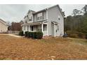 View of the home's side, showing the light gray siding, white trim, and a well-kept lawn at 216 Cobblestone Dr, Spring Lake, NC 28390