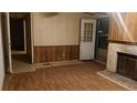 Living room featuring hardwood floors, wood paneling, and a classic brick fireplace at 22176 Nc 24-27, Cameron, NC 28326