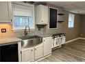 Close up on a kitchen sink, counter space and white cabinets with decorative metal accents at 4454 Wire Rd, Linden, NC 28356