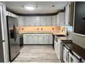 Well-lit kitchen featuring white cabinets, granite countertops, stainless steel appliances, and wood grain flooring at 4454 Wire Rd, Linden, NC 28356