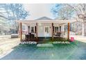 Home featuring a covered front porch with a swing, rock landscaping, and updated railings at 476 Riddle Rd, Sanford, NC 27330