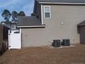 Home's side and backyard feature two AC units, a small extension, a white gate, and an adjacent home at 96 Boston Hbr, Cameron, NC 28326