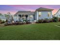 Expansive backyard with a covered porch, lush greenery, and plenty of space for outdoor activities at 405 Clovermist Ct, Sanford, NC 27330