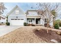 Charming two-story home with a well-manicured lawn, inviting front porch, and attached garage at 405 Clovermist Ct, Sanford, NC 27330