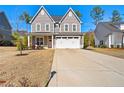 Inviting two-story home showcasing a well-manicured lawn and a double garage at 525 Falls Creek Dr, Spring Lake, NC 28390