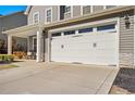 Spacious garage with a white door, and covered porch with seating at 525 Falls Creek Dr, Spring Lake, NC 28390