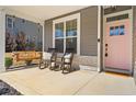 Welcoming front porch featuring rocking chairs and a charming pink front door at 525 Falls Creek Dr, Spring Lake, NC 28390