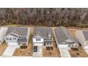 Aerial view of a two-story home featuring brick and siding exterior, driveway, and lawn with surrounding trees at 115 David Hill Dr, Sanford, NC 27330