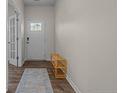 Bright entryway features wood-look flooring, shoe rack, and a glass panel door leading to another room at 115 David Hill Dr, Sanford, NC 27330