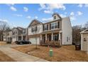 Street view of a two-story home featuring brick and siding exterior, front porch, well-maintained lawn, and driveway at 115 David Hill Dr, Sanford, NC 27330