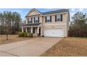 Inviting two-story home with a clean driveway leading to an attached garage and a cozy front porch at 262 Shepard Dr, Linden, NC 28356