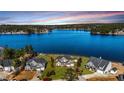 Panoramic aerial view showcasing a community by a beautiful blue lake surrounded by lush greenery at 107 Pelican Ct, Sanford, NC 27332