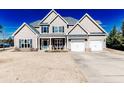 Inviting two-story home featuring a two-car garage, manicured lawn, and covered front porch at 107 Pelican Ct, Sanford, NC 27332