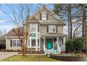 Attractive two-story home featuring a bay window and a welcoming front porch with a distinctive turquoise-colored door at 214 Pine Nut Ln, Apex, NC 27502