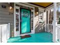 Close-up of the inviting turquoise front door with decorative details, sconces, and a white railing at 214 Pine Nut Ln, Apex, NC 27502