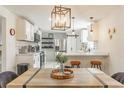 Bright, modern kitchen featuring white cabinets, stainless steel appliances, and stylish barstool seating at 711 Horton Rd, Durham, NC 27704