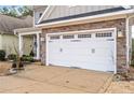 Spacious two-car garage door with decorative hardware, complemented by a stone facade at 929 Micahs N Way, Spring Lake, NC 28390