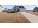 Inviting two-story home with a well-kept lawn, attached garage, and a welcoming front entrance with an American flag at 95 Southern Pl, Lillington, NC 27546