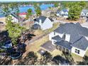 Aerial view of a backyard with a trampoline, patio, and lake in a lakeside community at 131 Southbrook Ln, Sanford, NC 27332