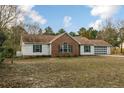 Classic single-story home with a brick facade, white siding, and an attached garage in a quiet, established neighborhood at 1425 Ponderosa Trl, Cameron, NC 28326