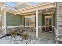 Charming front porch with stone accents, elegant columns, and a welcoming front door at 208 Planters Ln, Coats, NC 27521