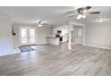 Open-concept living room with fireplace flows into kitchen, showcasing abundant natural light and modern flooring at 374 S Denise Ave, Coats, NC 27521