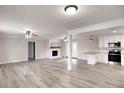 Spacious living room with white brick fireplace and opening into bright, updated kitchen at 374 S Denise Ave, Coats, NC 27521