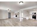Bright open living space featuring wood-look floors, painted brick fireplace, and seamless flow into the adjacent kitchen at 374 S Denise Ave, Coats, NC 27521