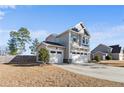 Side view of charming two-story home with a three-car garage and long driveway at 38 Heatherwood Dr, Lillington, NC 27546