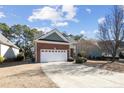 Exterior view showcasing a well-maintained home with a two-car garage and long driveway at 98 Cottswold Ln, Spring Lake, NC 28390