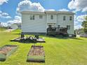 Spacious backyard with a raised deck, fire pit area, and garden beds, perfect for outdoor activities and relaxation at 11 Scotland Dr, Spring Lake, NC 28390