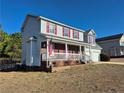 Two-story home with a covered front porch and a two-car garage on a sunny day at 11 Scotland Dr, Spring Lake, NC 28390